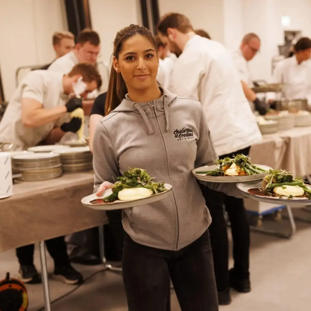 Kvinna bär tallrikar med mat